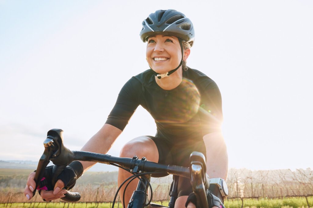 Kvinde smiler mens hun cykler