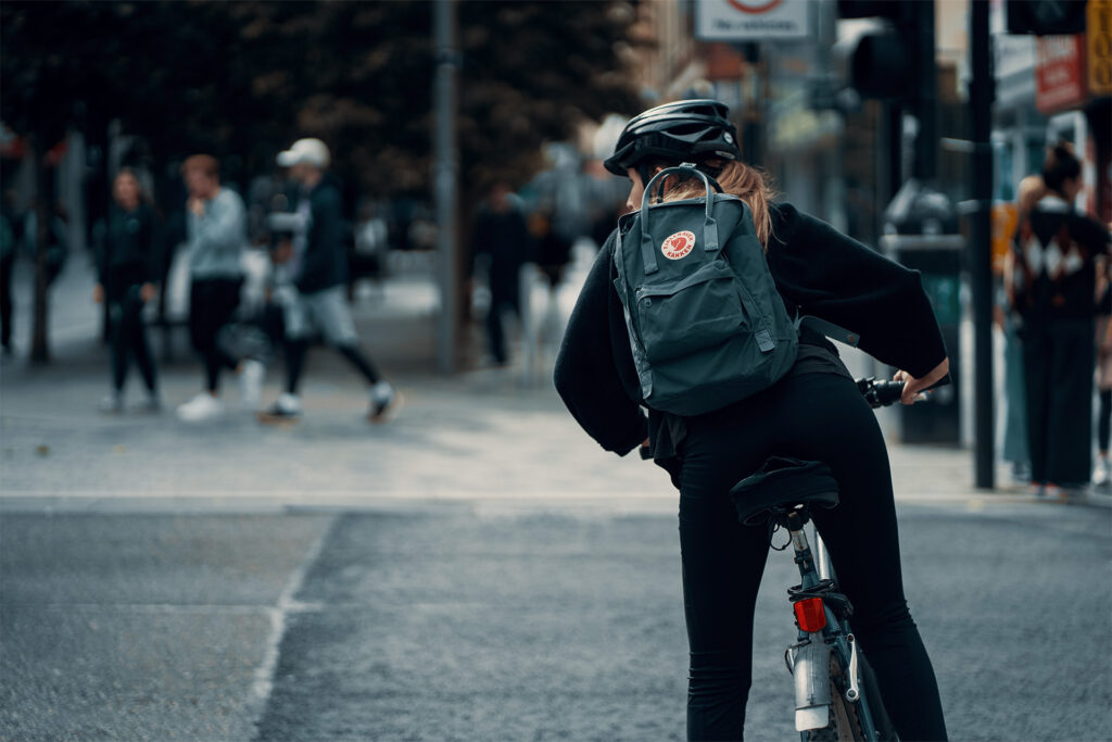 Kvinde i trafik på cykel inde i byen.