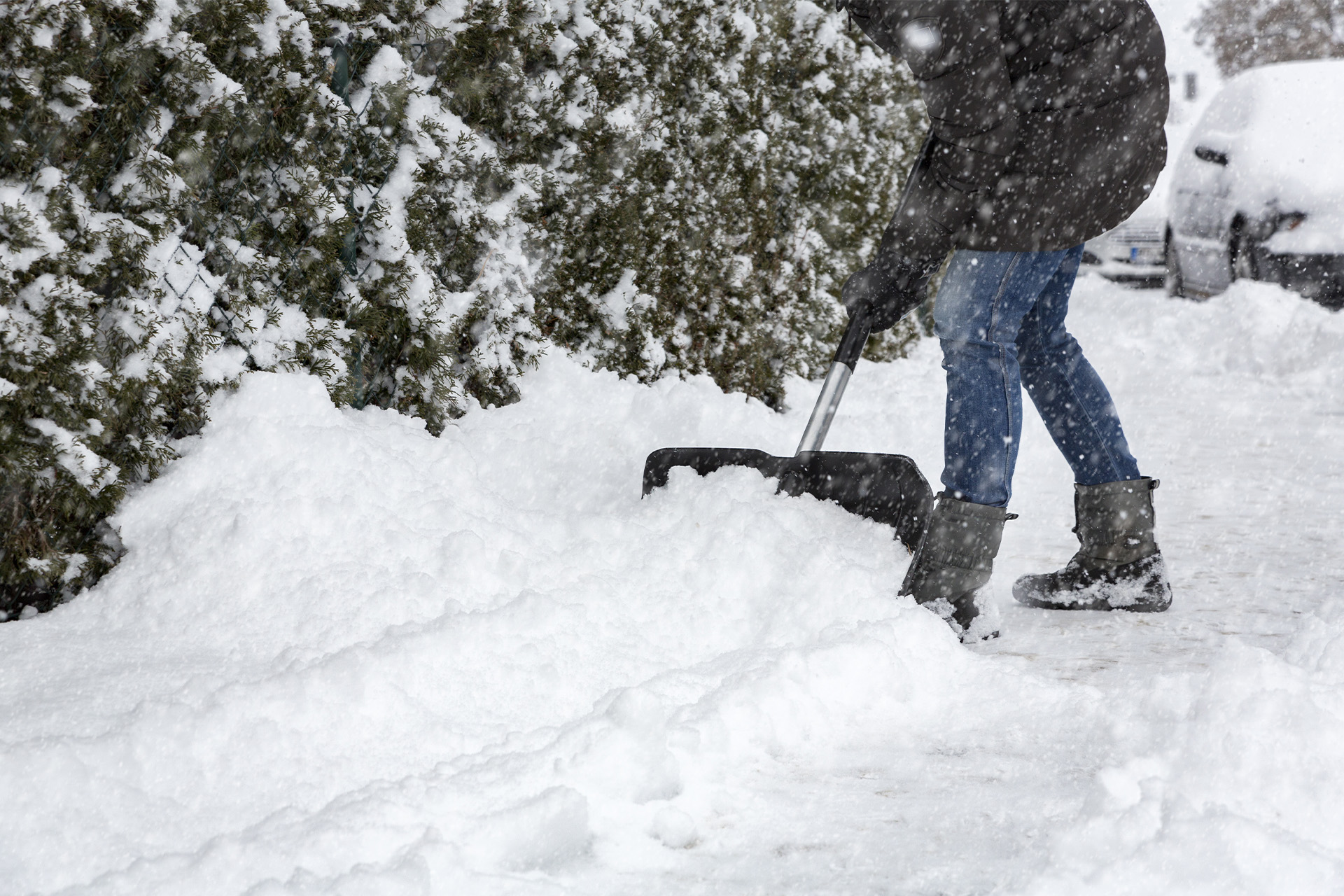 Mand rydder sne på fortov