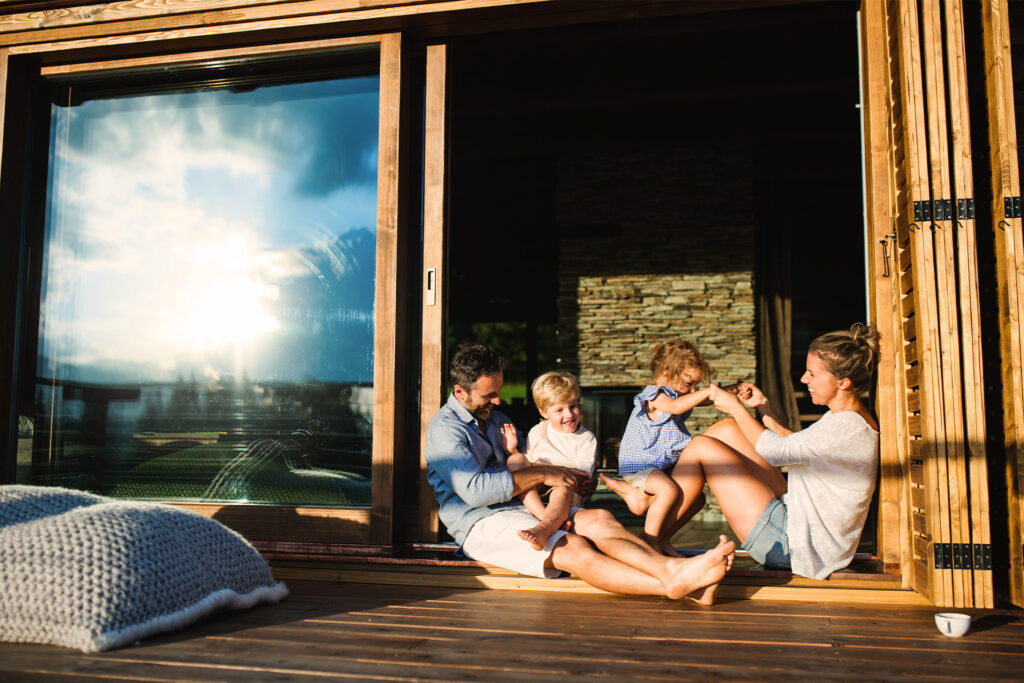 Familie sammen i sommerhus og smiler