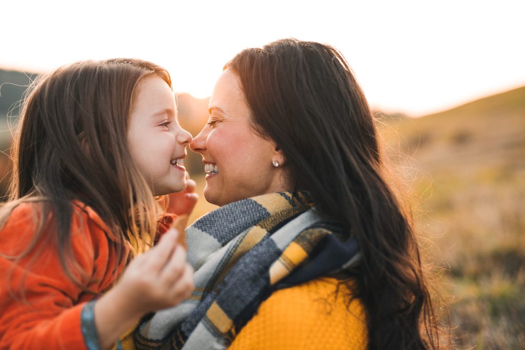 Mor og datter smiler til hinanden udenfor